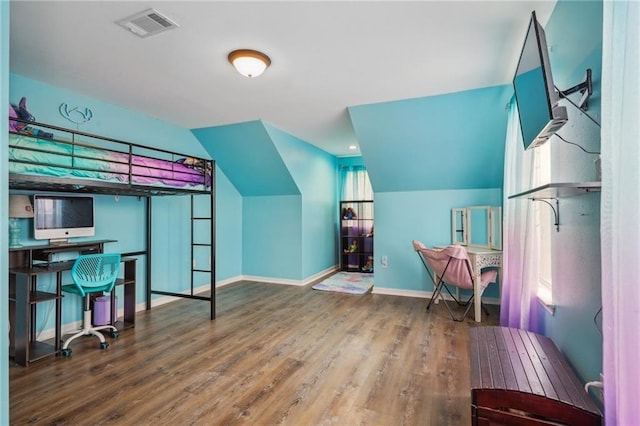 bedroom featuring baseboards, visible vents, wood finished floors, and lofted ceiling