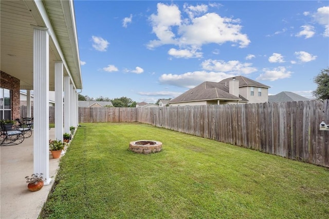 view of yard with a fenced backyard, a fire pit, and a patio area