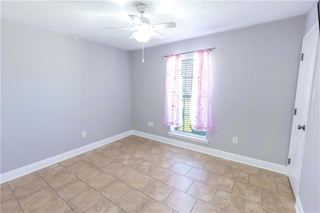 unfurnished room with baseboards, a ceiling fan, and a textured ceiling