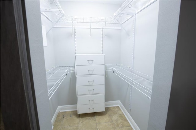 spacious closet with stone finish floor
