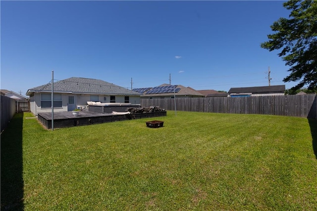 view of yard with a deck, a fire pit, and a fenced backyard