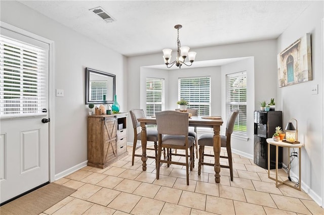 dining area featuring a chandelier, baseboards, visible vents, and a wealth of natural light