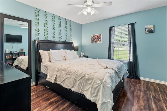 bedroom with a ceiling fan, baseboards, and wood finished floors
