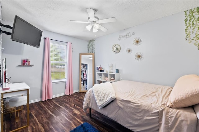 bedroom with baseboards, a ceiling fan, a textured ceiling, and wood finished floors