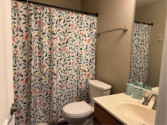 bathroom with toilet, a shower with shower curtain, and vanity