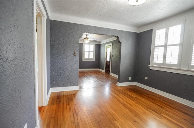 3220 48th St, Metairie, LA 70001 - unfurnished room with wood-type flooring, a textured ceiling, a textured wall, and arched walkways