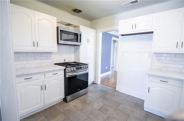 3220 48th St, Metairie, LA 70001 - kitchen with appliances with stainless steel finishes, decorative backsplash, light stone countertops, and visible vents