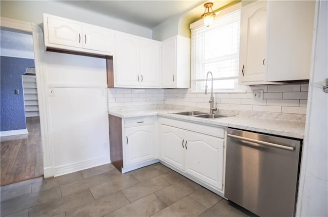 3220 48th St, Metairie, LA 70001 - kitchen featuring decorative backsplash, dishwasher, a sink, baseboards, and white cabinets