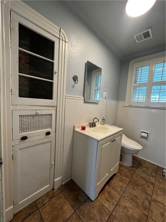 3220 48th St, Metairie, LA 70001 - bathroom featuring visible vents, tile patterned flooring, wainscoting, vanity, and toilet