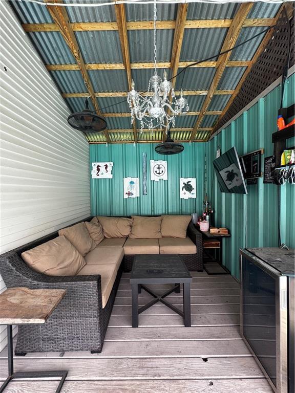 3220 48th St, Metairie, LA 70001 - living area with wood-type flooring, wine cooler, and an inviting chandelier