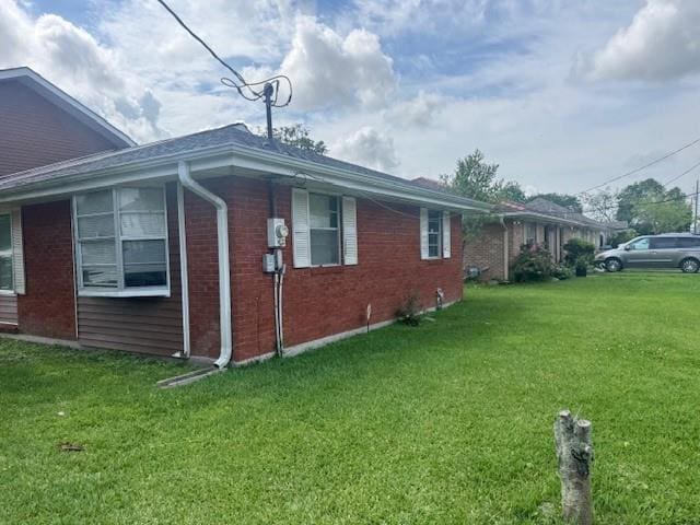 view of property exterior featuring a lawn and brick siding