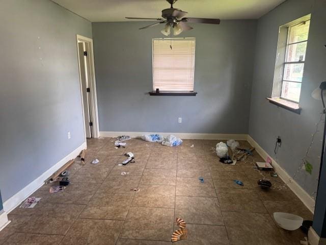 interior space featuring baseboards and ceiling fan