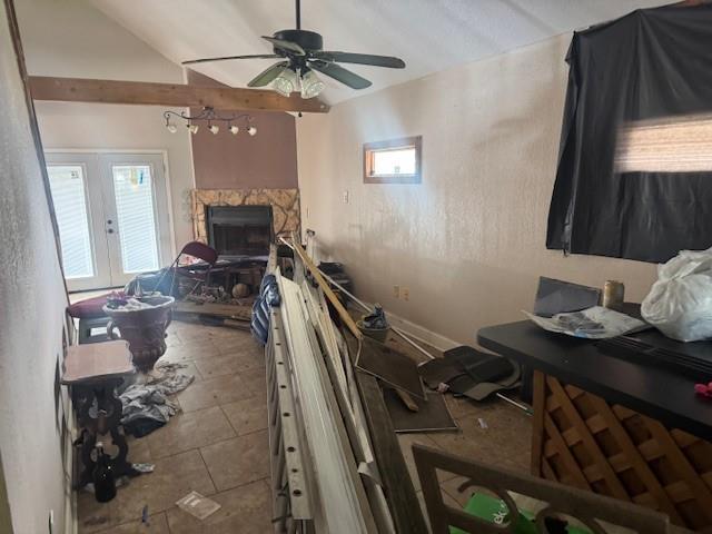 interior space with a ceiling fan and a stone fireplace