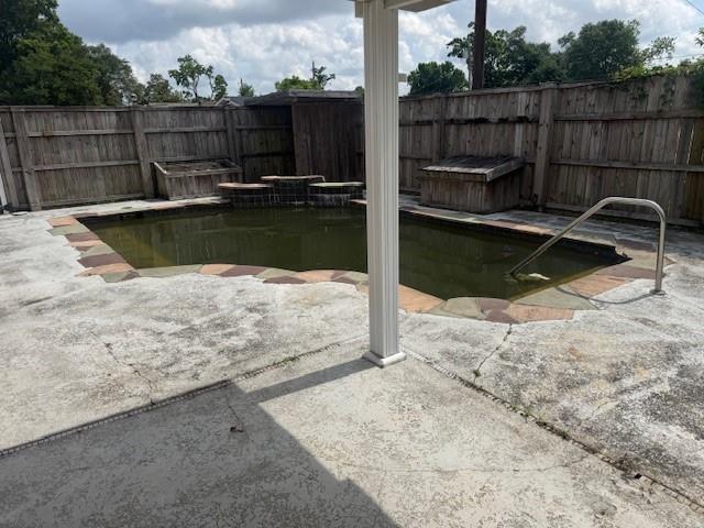 view of swimming pool with a patio and fence