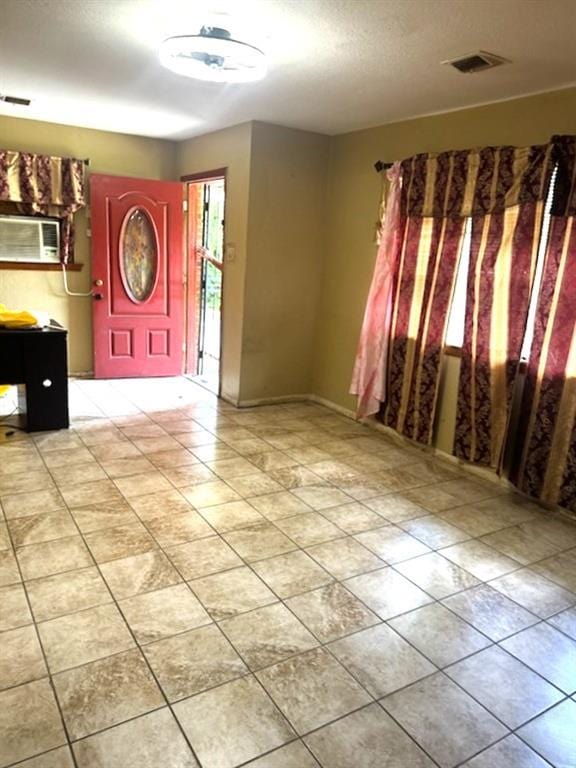 tiled entrance foyer with a textured ceiling and visible vents