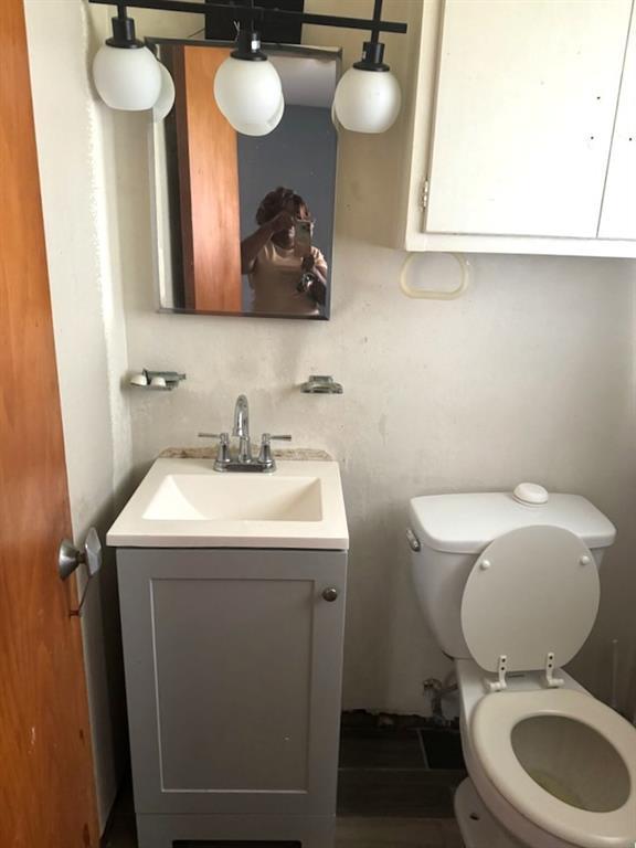 half bathroom featuring vanity and toilet