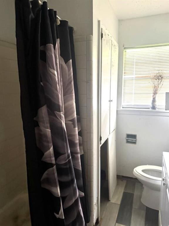 full bath with vanity, toilet, and tiled shower