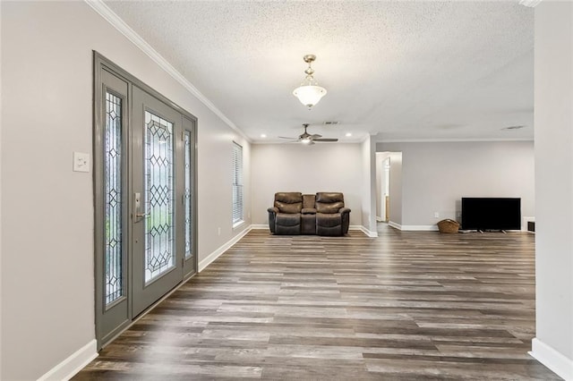 foyer entrance with crown molding, a textured ceiling, and wood finished floors
