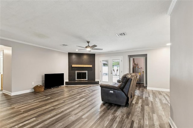 living room with wood finished floors, a ceiling fan, a textured ceiling, and visible vents