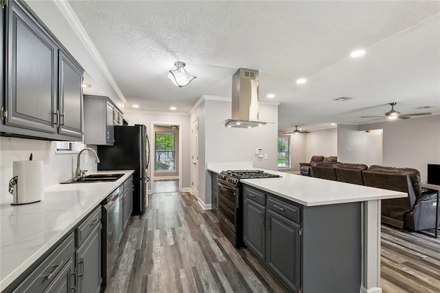 kitchen featuring gray cabinets, exhaust hood, a ceiling fan, open floor plan, and range with gas stovetop