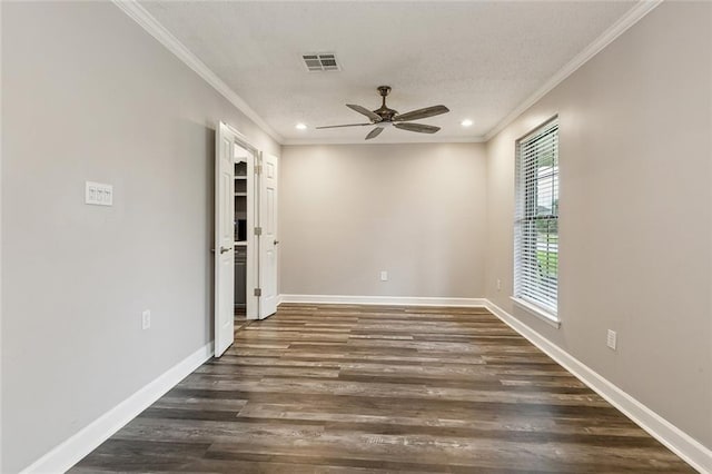 unfurnished room featuring a ceiling fan, dark wood finished floors, ornamental molding, and visible vents