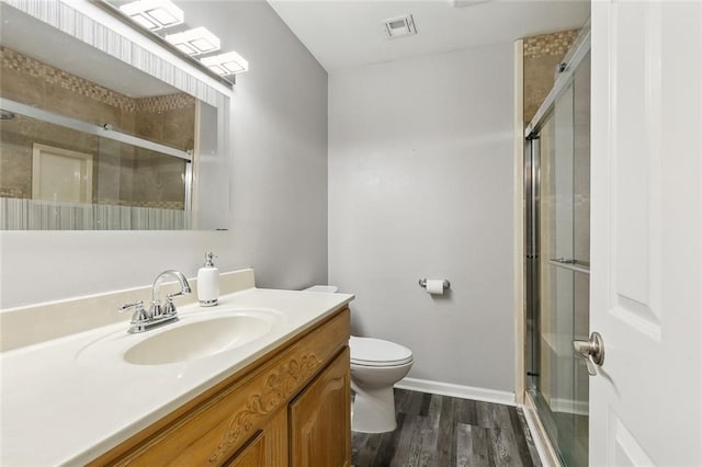 bathroom with visible vents, a stall shower, toilet, and wood finished floors