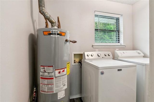 clothes washing area with water heater, laundry area, and washing machine and dryer