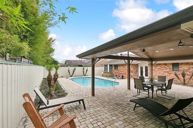 view of swimming pool featuring ceiling fan, a fenced in pool, a fenced backyard, french doors, and a patio