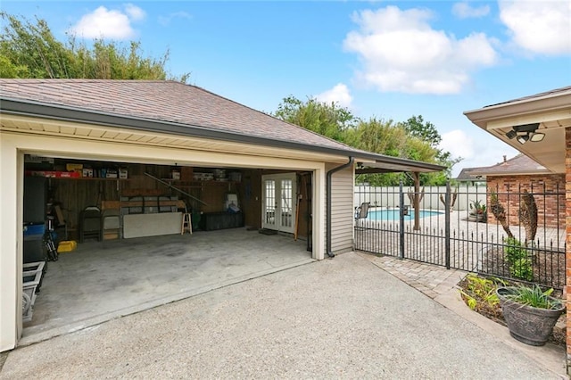 view of home's exterior with french doors, fence, a fenced in pool, and a shingled roof