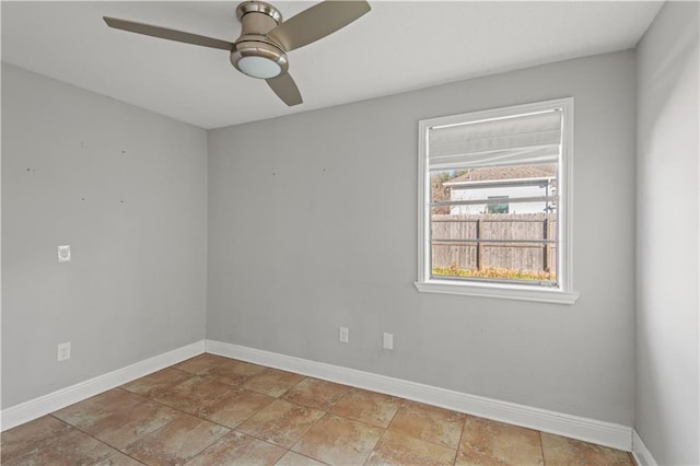 spare room with baseboards and ceiling fan