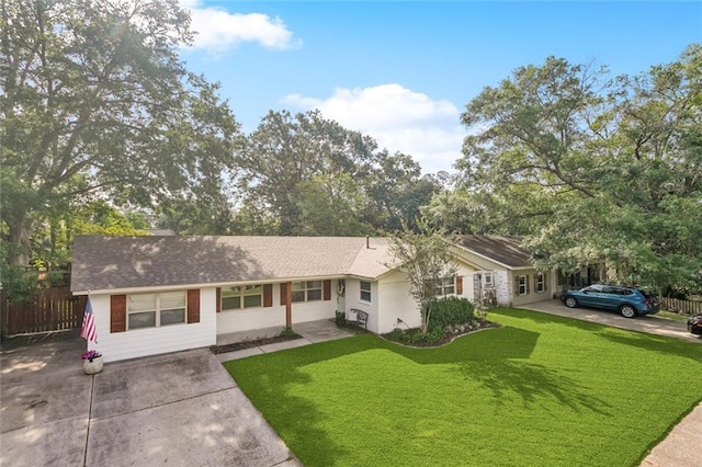 ranch-style house with fence, a shingled roof, driveway, and a front lawn