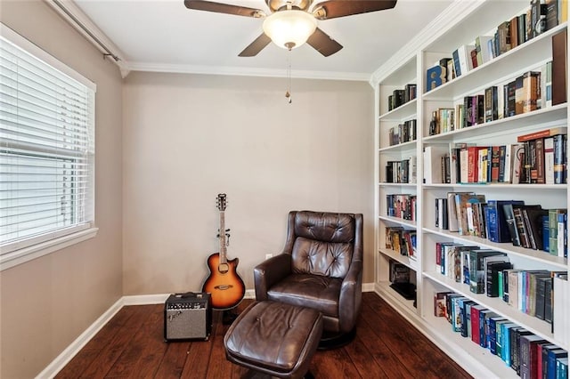 sitting room with wood-type flooring, ceiling fan, ornamental molding, and baseboards