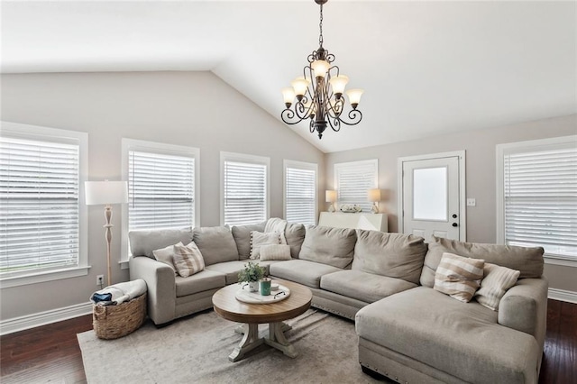 living area with baseboards, lofted ceiling, wood finished floors, and a chandelier