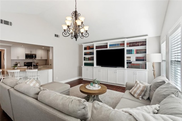 living room featuring an inviting chandelier, high vaulted ceiling, dark wood finished floors, and visible vents