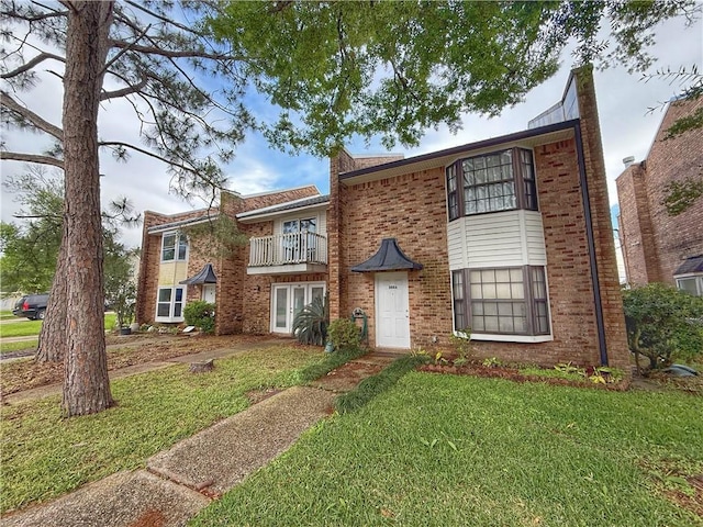 308 Ormond Meadows Dr Unit B, Destrehan, LA 70047 - view of front of house featuring brick siding, a front lawn, and a balcony
