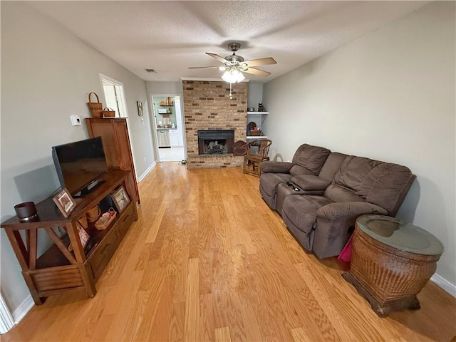 308 Ormond Meadows Dr Unit B, Destrehan, LA 70047 - living area with a ceiling fan, baseboards, light wood-style flooring, and a fireplace