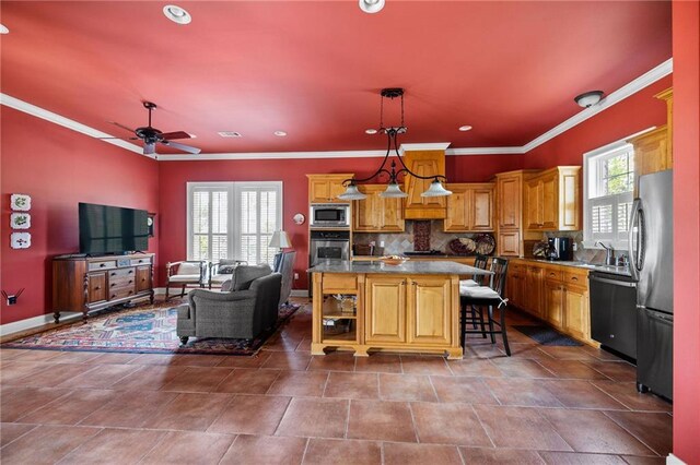 609 W Dakota St, Hammond, LA 70401 - kitchen featuring decorative backsplash, a ceiling fan, appliances with stainless steel finishes, open floor plan, and ornamental molding