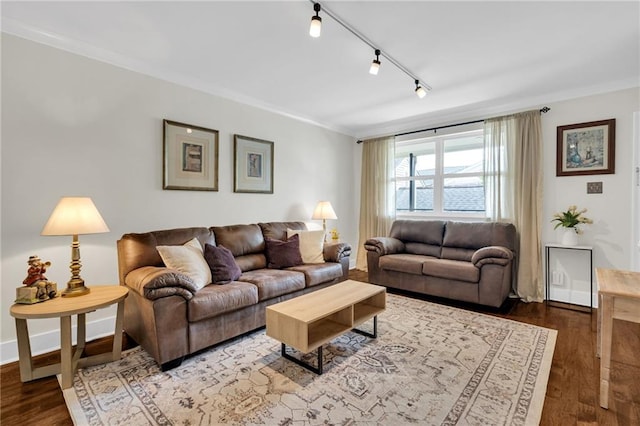 living room with crown molding, rail lighting, baseboards, and wood finished floors