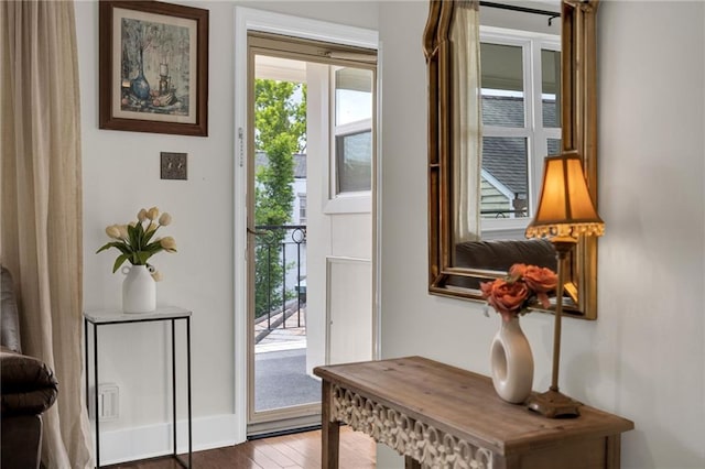 doorway featuring baseboards and wood finished floors