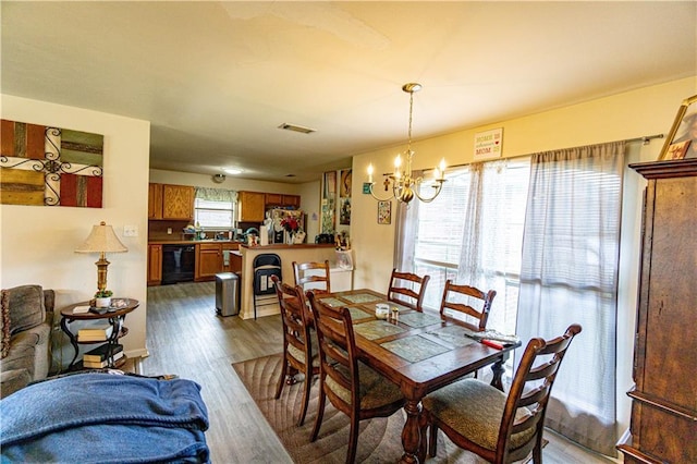 11257 Abbey Ln, Denham Springs, LA 70726 - dining area with visible vents, wood finished floors, and a notable chandelier