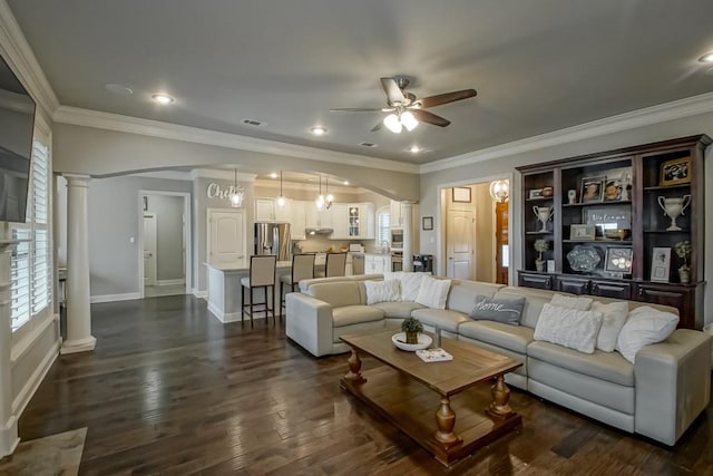 living area with crown molding, arched walkways, a ceiling fan, ornate columns, and visible vents