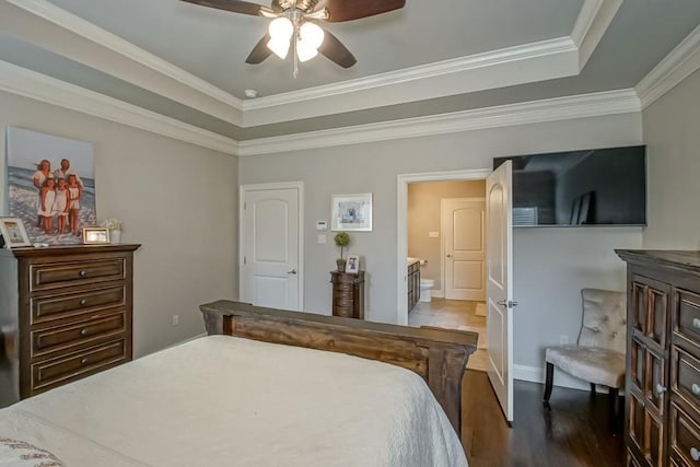 bedroom featuring a ceiling fan, crown molding, wood finished floors, a raised ceiling, and connected bathroom