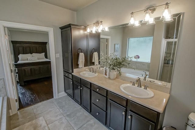 ensuite bathroom featuring a sink, double vanity, and connected bathroom