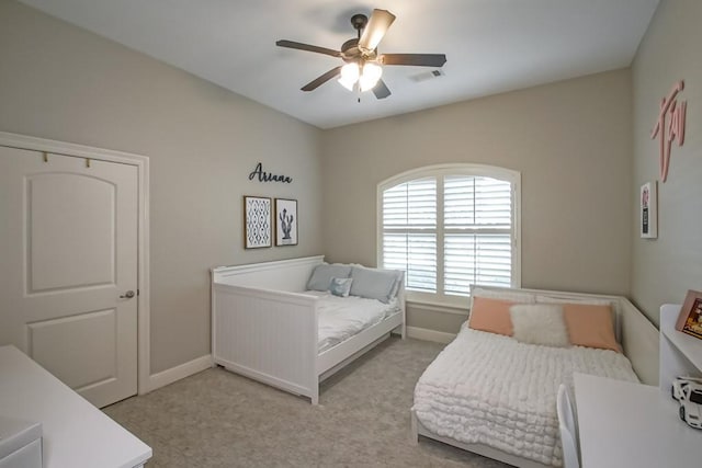 bedroom featuring baseboards, visible vents, a ceiling fan, and light colored carpet