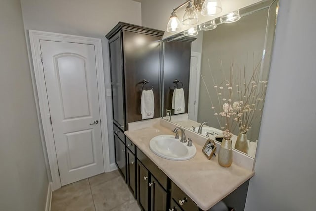bathroom with vanity, baseboards, tile patterned floors, and an inviting chandelier