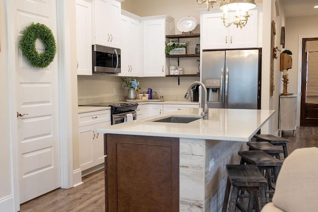 109COUSHATTACIRCLE Coushatta Cir, Madisonville, LA 70447 - kitchen with stainless steel appliances, a sink, open shelves, a breakfast bar, and white cabinets