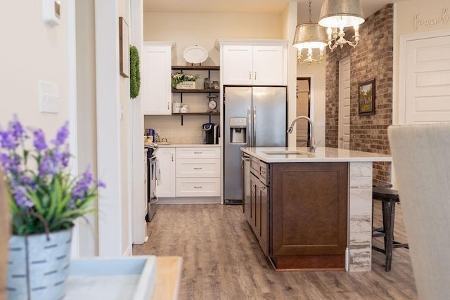 109COUSHATTACIRCLE Coushatta Cir, Madisonville, LA 70447 - kitchen featuring a sink, open shelves, stainless steel appliances, light countertops, and wood finished floors