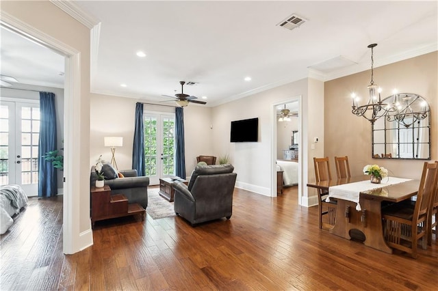 living room featuring crown molding, ceiling fan with notable chandelier, and dark wood-style floors