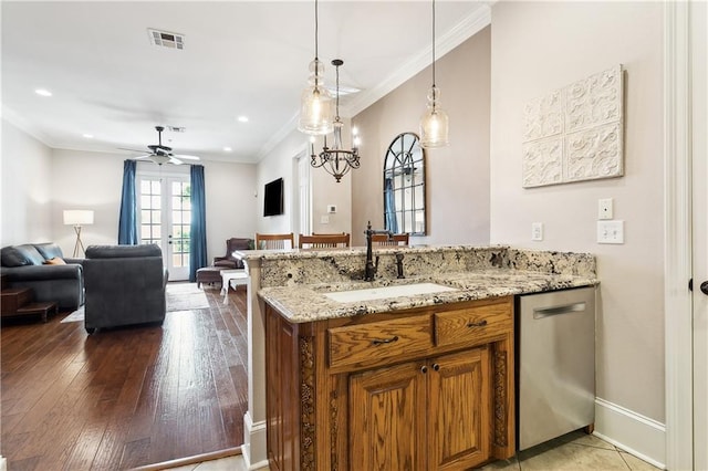 kitchen featuring a peninsula, ceiling fan, brown cabinets, a sink, and dishwasher