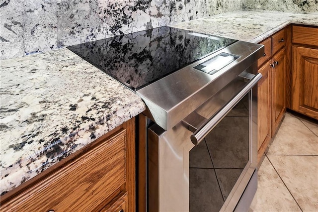 details featuring light stone counters and brown cabinets